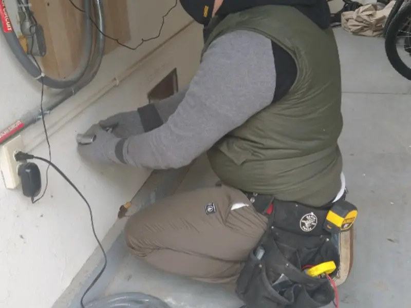 Electrician performing outlet wiring in a East Milton garage